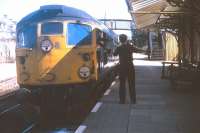 A non-stop freight from the north exchanges tokens at speed with the Invergordon signalman in early 1974. With Inverness loco drivers going by nicknames such as 'The Cowboy' and 'The Bandit', manual exchange of tokens could be a hair-raising experience, as the photographer remembers only too well from his time as a temporary BR employee doing (unofficial) signalling duties!<br>
<br><br>[David Spaven //1974]