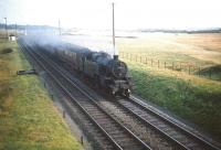 Fairburn 2-6-4T no 42131 has just passed Lochgreen Junction, Troon, heading north on 21 August 1959. The train is on what was then the 'down branch line' with the 'main line' (the now closed Troon avoiding line) running off to the left at the junction. The train is the 5.10pm Ayr - Kilmarnock mail & passenger, conveying a through Royal Mail sorting van next to the locomotive. The mail van would be transferred to the rear of the 5.30pm Glasgow St Enoch - Carlisle train at Kilmarnock and, on reaching Carlisle, would be attached to the up 'West Coast Postal'.<br><br>[A Snapper (Courtesy Bruce McCartney) 21/08/1959]