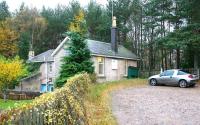 The former station at Dinnet, between Ballater and Aboyne, seen looking south on 10 November 2006. Platform remains stand beyond the fence and at the time of the visit the building itself was in use as an estate office. Note the totem in place on the front of the building.  <br><br>[John Furnevel 10/11/2006]