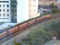 Drop bags... find camera... grab shot of DBS 66017 with a loaded coal train running through Cardiff Queen Street heading for Cardiff Central on the evening of 19 April 2011. At the far side of the car park, above the loco, an ATW DMU can be seen on the South Wales main line. Seen from the 7th floor of the Premier Inn alongside Queen Street station. <br><br>[David Pesterfield 19/04/2011]