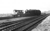 An ex-works 8F 2-8-0, possibly 48475, shunts Longridge Goods Yard, thought to be around 1966. This view is from the level crossing by the station looking towards the quarries and the 1:50 gradient can be seen on the right. [See image 33840] for the same location in 2011.<br><br>[David Hindle Collection //1966]