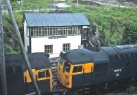 A pair of type 2s alongside the signal box at Kyle of Lochalsh in 1977. The locomotives were getting ready to return to Inverness with a special.<br><br>[Bruce McCartney //1977]