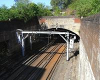 It's difficult to get a decent shot of the platform side of the former Glasgow Green station (closed 1953) as it's between tunnels and the only viewpoint is an overbridge across the middle with high walls. Nevertheless here we go. This view looks towards the city centre. The rear of the fine facade can be made out, as can the the site of the top of the stairs to the platforms. Argyle line trains continue to pass through here every few minutes.<br><br>[David Panton 02/05/2011]