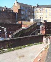 The current Bridgeton station (beyond the wall) is only half the <br>
station it once was. It used to be a junction for the line to Carmyle - and eventually Coatbridge Central. The course of the sharp divergence at this point can be seen here in the foreground on 2 May 2011. Both lines and the station closed in 1964, but the line through the Rutherglen platforms reopened in 1979 with a station called plain Bridgeton. <br>
<br><br>[David Panton 02/05/2011]