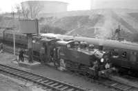 USA 0-6-0T locomotives 30064+30069 replenishing their tanks in the sidings alongside the UKs largest oil refinery at Fawley on Southampton Water. The visit was part of the LCGB <I>Hampshire Branch Lines Rail Tour</I> on 9 April 1967, with the pair having brought in the special on the leg from Southampton Central. <br><br>[Robin Barbour collection (Courtesy Bruce McCartney) 09/04/1967]