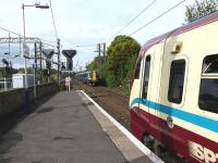 Southbound 380110+380012 about to enter Kilwinning station on 6 May, just as 334039 prepares to leave with a service for Glasgow Central.<br><br>[Ken Browne 06/05/2011]