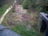 Looking South from the road bridge at the former Rugby Central station in March 2011 we notice, left to right: the foot/cycle path; the edge of the old down platform; murky green stagnant water very similar to that at Lutterworth; and the former support wall for the station building.<br><br>[Ken Strachan 29/03/2011]