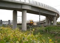 The 11.07 Edinburgh Waverley - Milngavie train about to pass under the tram flyover at Edinburgh Park on 31 May shortly after leaving the station.<br><br>[John Furnevel 31/05/2011]