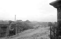 A 1974 view south past the remains of the viaduct that carried the Caledonian 'Leith New Lines' over the trackbed of the NB North Leith branch. The abutment on the extreme right stands at the bottom of Gosford Place and Bonnington station is off picture to the left. The viaduct spanned Bonnington East Junction where the NB line split 3 ways. The branch south met with the line from Granton (the embankment running right to left across the centre of the picture) at Bonnington South Junction, just north of Powderhall station - now occupied by the refuse disposal depot left of centre. The line straight ahead ran to Warriston Junction where it joined the original Granton - Canal Street line to the north of Scotland Street. The third branch turned north to join the Granton line at Bonnington North Junction. [See image 2196]<br><br>[Bill Roberton //1974]