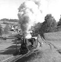 760mm gauge Engerth type 0-8+4T No. 399.02 leaves Steinbach-Grosspertholz in the Waldviertel area of Lower Austria on the 05.05 Gmnd to Gross Gerungs freight on 2 June 1977. The train is commencing the ascent of the 'Little Semmering', which might be something of an exaggeration but certainly involved a stiff climb over the European water-shed to reach the end of the line at Gross Gerungs. Sharp eyes might be able to pick out my Mini parked adjacent to the station building. <br>
<br><br>[Bill Jamieson 02/06/1977]