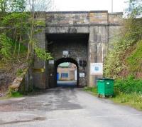 Beyond the former terminus at Penicuik a line ran south to reach Bank Mill on the other side of the A701 [see image 29992]. One of the mills that made up the Valleyfield complex of Alexander Cowan & Sons, Bank Mill had started life as a corn mill before being bought over and converted to a secure facility making bank notes. View west through the short single line rail tunnel under the A701 on 9 May 2011 with Bank Mill standing beyond. [Behind the camera the site of Penicuik station and Valleyfield mill is now housing.]<br><br>[John Furnevel 09/05/2011]