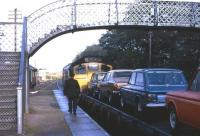 Hillman Imps to the fore on a sunny morning in May 1974 as the Tain signalman (Malcolm), delivers the token for the section to Bonar Bridge to the driver of the Class 24 hauling the daily Inverness-Wick freight.<br><br>[David Spaven /05/1974]