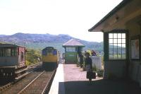 A Class 27 slows its Mallaig-bound train into Arisaig in the summer of 1977, while a sister locomotive on an engineer's train waits in the distant sidings.<br><br>[Frank Spaven Collection (Courtesy David Spaven) //1977]