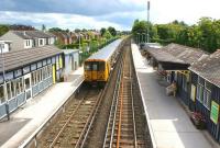 View south from the footbridge at Ainsdale station on a warm and sunny 26 June 2011 as a Southport - Liverpool Central service pulls away from the platform.<br><br>[John McIntyre 26/06/2011]