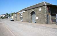 Scene at Castle Douglas in July 2011 looking south west from what was once the town's goods yard. The substantial old goods shed survives as a building supplies and DIY centre, while the white building in the left background on the other side of Oatwell Road still carries the name 'Station Hotel'. Off to the right, behind the goods shed, the site of the former station itself (closed June 1965) is now occupied by a Tesco supermarket and car park.<br><br>[John Furnevel 03/07/2011]