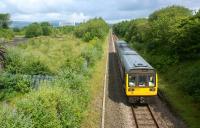 A Blackpool South to Colne service has left Burnley Central en-route to Brierfield on 9 July 2011. This view north from Danes House Road bridge is almost unrecognisable from that of 50 years ago. At that time it was double track and ran all the way to Skipton, the area on the left was a reasonable sized goods yard and there would not have been many trees around except in the far distance beyond the gasometer.<br>
<br><br>[John McIntyre 09/07/2011]