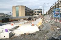 Track now in place at the Haymarket tram interchange on 10 July 2011 between the station car park and Haymarket Terrace. The route ahead will turn south west between the two buildings on the left before continuing west towards the next stop at Murrayfield.<br><br>[John Furnevel 10/07/2011]