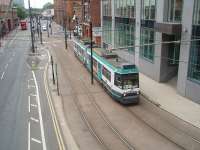 For almost twenty years all trams to Manchester Piccadilly terminated in the undercroft station, but the new line to Droylsden opened in 2012 and will later extend to Ashton-under-Lyne. First of the Metrolink fleet No. 1001 climbs away from Piccadilly back to the city centre. The bridge in the background carries the railway line from Manchester Oxford Rd. <br><br>[Mark Bartlett 12/07/2011]