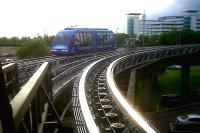 The 'maglev' shuttle at Birmingham Airport [See image 19857] was replaced by a pair of cable-hauled driverless pods - one blue, one green. As can be seen on the track on the right, the cables run over many pulleys. This gives the strange result that the sound of moving parts is audible whenever the pods are in motion, whether you can see them or not! Despite the legend on the side of the pod, it doesn't actually go all the way to Australia..<br><br>[Ken Strachan 21/07/2011]