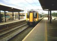 A down 350 calls at Bletchley in June 2011. The viaduct in the background was built about 1960 for access to Swanbourne yard - which was never built, due to the rapid decline in wagonload traffic. The viaduct may yet be used for a revived East-West link, if they can afford to attach a platform and lifts to it. In 1985, I saw an empty stock DMU with saloon lights lit crossing from East to West - a rather fetching sight at dusk.<br><br>[Ken Strachan 10/06/2011]