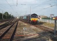 Taking the <I>back road</I> at Carnforth, ready for a crew change at the far end of the station, are a sparkling 66428, sister 66417 and five nuclear flask wagons on the 6C53 Crewe to Sellafield. On the right, DRS BRCW Type 3 No. 33030 can be seen in store with other locos in the West Coast Railway yard. The Sellafield trains were diverted via Carlisle for a period in early 2011 [See image 33441] while Arnside viaduct was repaired but are now taking the coast line through Ulverston again. <br><br>[Mark Bartlett 28/07/2011]