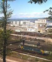 With Ben Wyvis clad in late spring snow, a Class 47 passes Welsh's Bridge box, Inverness, in 1977 on the last few hundred yards of its journey from the south.<br><br>[Frank Spaven Collection (Courtesy David Spaven) //1977]