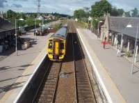 Nairn, looking towards Inverness in June 2011, as 158701 approaches on an Aberdeen service. The <I>norm</I> is reversed at Nairn in that the right hand (bi-directional) platform is used for all trains to Inverness and also those to Aberdeen that aren't crossing another service here. The left hand platform can only be used by Aberdeen bound trains. The buildings on both sides are used by a variety of local businesses, as well as housing the ticket office and signalling centre.  <br><br>[Mark Bartlett 30/06/2011]