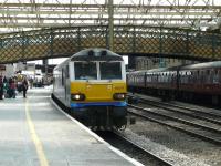 Stobart Rail's 92017 <I>Bart the Engine</I>, runs through Carlisle platform 4 on 30 July with the well loaded 4S43 Rugby - Mossend Tesco containers. The ECS of the 'Cumbrian Mountain Express' stands at the adjacent platform 3.<br><br>[Ken Browne 30/07/2011]