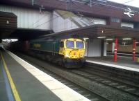 Freightliner 66567 emerges from the stygian depths of Birmingham International with a Northbound container train on 21 July. The light was starting to fade, but the train was just restarting after a crew change.<br><br>[Ken Strachan 21/07/2011]