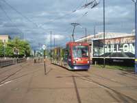 Midland Metro tram 04 arrives at the Wolverhampton St. Georges terminus on an early evening service from Birmingham Snow Hill in June 2011.  Although the station was built for two track working, and a possible extension, all trams arrive and depart from the same platform. Most of the route follows the old GWR main line except for a short street running section from Priestfield to the Wolverhampton terminus. [See image 34444]<br><br>[Mark Bartlett 08/06/2011]