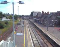 Elevated view south towards Gretna from the 2008 footbridge at Lockerbie on 3 August 2011. Centre right is the south end of the infilled bay once occupied by the platforms of the Dumfries, Lochmaben and Lockerbie Railway, with its own entrance and overall roof. The line lost its passenger service in 1952 and closed completely in 1966. The roof was removed and the bay infilled in the 1970s [see image 2704].<br><br>[Andrew Wilson 03/08/2011]