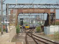 Framed by the footbridge that provides the sole access to Ardwick's island platform, 323229 passes over Ardwick Junction on its way to Stockport.  The junction was where the GCR met the LNWR outside Manchester (London Rd) station.  The right hand of the two lines in the foreground leads into Ardwick depot, opened in 2006 to maintain the TPE Class 185 fleet.<br><br>[Mark Bartlett 03/08/2011]