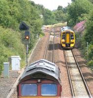 The 14.04 Edinburgh Waverley - Dunblane DMU approaches Falkirk Grahamston on 25 July 2011. The train is about to pass DBS 66147, held at signals as it waits to run light engine to the W H Malcolm depot on the Grangemouth branch to pick up a freight. The hold-up is due to a train on the branch waiting to reverse back into Grahamston station with a return Queen Street via Cumbernauld service.   <br><br>[John Furnevel 25/07/2011]