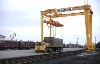 A modern container crane dominates Elgin's busy freight depot in the early summer of 1977. Nowadays the crane is still there (just) but rail freight activity has been only occasional for some years [see image 18087].<br><br>[David Spaven //1977]