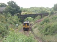 Having made a request stop at lonely Entwistle 150268, on a Clitheroe to Manchester Victoria service, accelerates away on the falling gradient towards Bromley Cross where double track resumes. The 737' summit of the line is at Sough Tunnel. The marker board to the left warns of the level crossing at the closed station of Turton and Edgeworth.<br><br>[Mark Bartlett 23/07/2011]