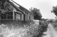 Line side at Cardrona looking north west towards Peebles in 1975 with the platform being used for storage purposes by the local farmer. The building, including the former signal box (nearest the camera) was later converted for use as the local shop [see image 30217].<br><br>[Bill Roberton //1975]