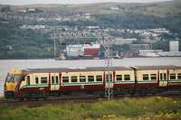 334034 heads east past the mid section of the first Queen Elizabeth Class aircraft carrier en route from Govan to Rosyth.<br><br>[Ewan Crawford 16/08/2011]