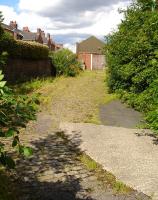 The boarded up former Dewsbury and Ossett Tramways tram shed off Church Street, Ossett, in July 2011. The trackbed is still discernible down through the yard entering from the right and curving round to enter the two road tram shed, only the left section of which is visible. The building was for many years an appliance repair workshop for Yorkshire Electricity up to the early 1970s - I spent part of my electrical apprenticeship here. It later became a manufacturing site for playground equipment.   <br><br>[David Pesterfield 06/07/2011]