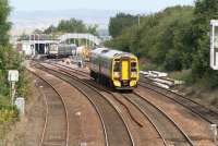 A Fife Circle train returning to Edinburgh heads south from Dalmeny on 22 August 2011. At the down platform in the background an outbound service prepares to head for the Forth Bridge.<br><br>[John Furnevel 22/08/2011]