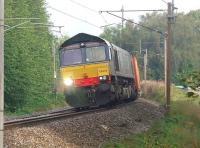 With signals at <I>Caution</I> because of the preceeding 8F hauled train (How often can you write that in a caption these days?) DRS 66424 maintains a slow but steady climb up the bank from Lancaster station on 24 August with a long southbound container train. [See image 35365]<br><br>[Mark Bartlett 24/08/2011]