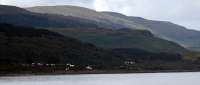 Farewell Mull Railway. Victoria and her coaches can just be seen heading south from Craignure station in this view from 'Isle of Mull' passing Lady's Rock. The plume of smoke can be seen to the left close to the shore and the signalpost and station are to the right.<br><br>[Ewan Crawford /08/2011]