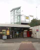 The modern structures at Old Roan near Aintree. Like many Merseyrail stations it is a bit non-descript at platform level but worth a second look from the street. This view was taken from the bus area of the Old Roan interchange and looks towards the booking office. It also shows the lift for the Ormskirk platform and the subway to the Liverpool platform, which also has a similar glass lift tower. Old Roan station opened in 1935 to serve housing developments to the north of Aintree. <br><br>[Mark Bartlett 25/08/2011]