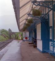 Taynuilt looking to Crianlarich in 1990. The building was in use as West Highland Brewers / Brewery and Station Tap pub at the time. A few years later it was to succumb to junior arsonists. This building, like most on the line, was assembled from a sort of flat-pack sent out from Glasgow by train. Around 1990 the out of use signalbox was re-located from the west end of the station to the east end (it is just visible in the new location).<br><br>[Ewan Crawford //1990]