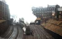 A Black 5 storms out of Edinburgh's Princes Street station with the 1.20 pm service to Lanark on 2nd November 1964. Nowadays this view - from Grove Street towards Morrison Street - is dominated by the Western Approach Road, but the tenements in the middle distance and the 'colonies' to the right still survive. [See image 18413]<br><br>[Frank Spaven Collection (Courtesy David Spaven) 02/11/1964]