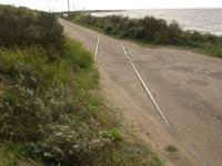 Track crossing the south end of the undamaged north section of the causeway to Spurn Point showing the extent of land erosion here. Spurn Point lighthouse can be seen across the water. <br><br>[David Pesterfield 28/08/2011]