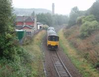 On a wet September afternoon a Clitheroe to Manchester Victoria service climbs south from Darwen and passes the remains of Spring Vale station, closed in 1958, seen from a bridge overlooking the station site. Just round this bend 150140 will enter Sough tunnel from where it will begin the descent to Bolton. [See image 33698] for a view from a steam special passing the same point in 1968.<br><br>[Mark Bartlett 08/09/2011]