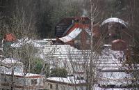 The view east over a sea of static caravans at the St Fillans station site. The station building can be seen over the caravans, with a modern house just beyond. February 2011.<br><br>[Ewan Crawford /02/2011]