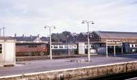 Cross-platform view at Newton Abbot station in July 1969, with D1012 <i>Western Firebrand</i> hauling a rake of carriages through the washing plant.<br><br>[John McIntyre 30/07/1969]