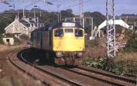 A BRCW Type 2 heads west through Cardross with the evening Glasgow Queen Street - Fort William service in March 1975, with the low sun catching the front of the locomotive.<br>
<br><br>[John McIntyre /03/1975]