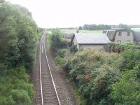 Early morning view looking east towards Nairn from the overbridge at Gollanfield. The old station, once the junction for Fort George, is the more distant of the two buildings alongside the track. Although it closed in 1965 it is still in residential use. For the view west from the same overbridge [See image 34727]. <br><br>[Mark Bartlett 01/07/2011]